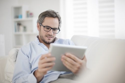 Attractive Man At Home Using Digital Table